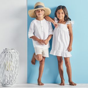 Niña y niño posando con prendas de la colección Allegra de la marca Babidú.